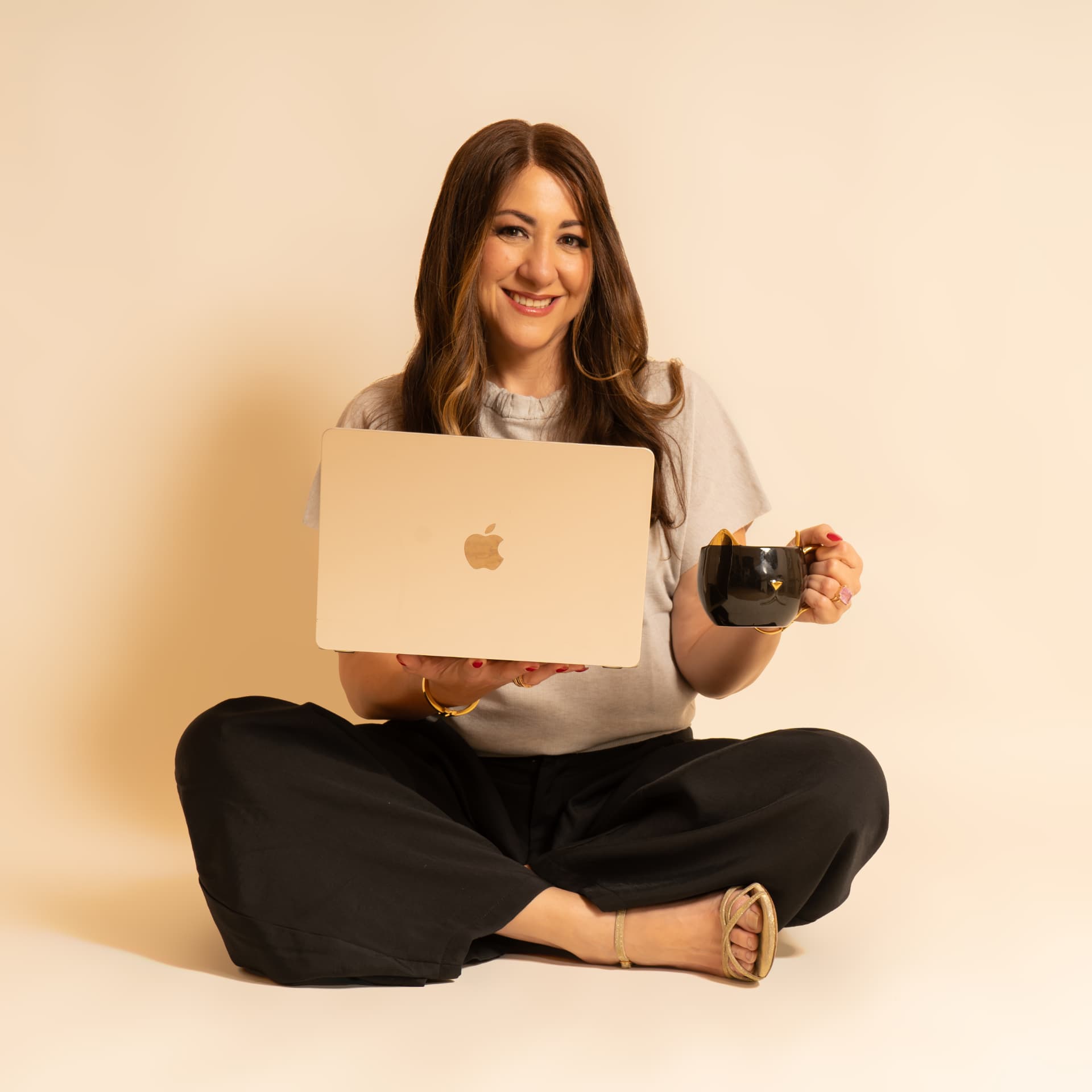 Daniela Correa sentada con su laptop y una taza